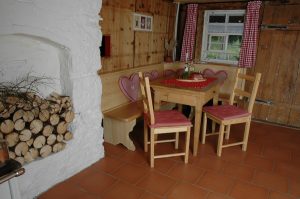Ferienhaus Erdgeschoss: Tisch mit Eckbank und Stühlen in der Küche