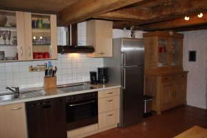 Ferienhaus Erdgeschoss: Küchenzeile mit großem Kühlschrank (mit Gefrierfach) und Oma's traditionellem Küchenschrank