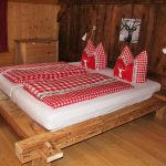 Ferienhaus Obergeschoss: rustikales Balkenbett aus Altholz im Altholz-Schlafzimmer