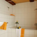 Ferienhaus Obergeschoss: großes Bad mit Badewanne (und Duschkombination) und WC