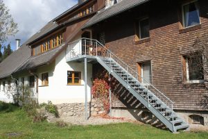 Ferienwohnung Außenbereich: Treppe mit Plattform als Zugang zur großen Terrasse