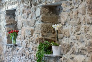 Ferienwohnung Innenräume: Hausflur mit erhaltener Steinwand und Blumennische