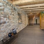 Ferienwohnung Innenräume: weiträumiger Hausflur mit erhaltener Steinwand und Treppenhaus im Winter