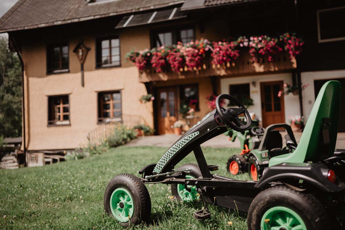 Spiel und Spaß Erlebnisbox: das Trampolin, Spielhäuschen mit Rutsche und Schaukeln und Fahrzeugen
